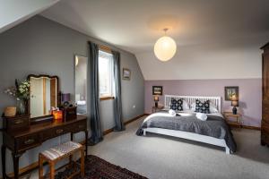 a bedroom with a bed and a desk and a mirror at Shorefield, Bruichladdich in Bruichladdich