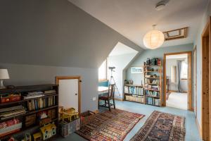 Shorefield, Bruichladdich في Bruichladdich: غرفة معيشة مع سجادة ورف كتاب