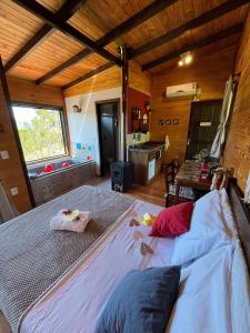 a bedroom with two beds in a room with a kitchen at Chalés incríveis com banheira de hidromassagem e vista encantadora in Urubici