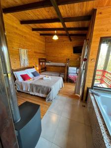 1 dormitorio con 1 cama en una habitación de madera en Chalés incríveis com banheira de hidromassagem e vista encantadora, en Urubici