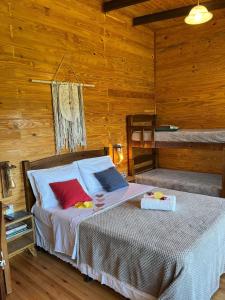 a bedroom with a bed with two bunk beds at Chalés incríveis com banheira de hidromassagem e vista encantadora in Urubici