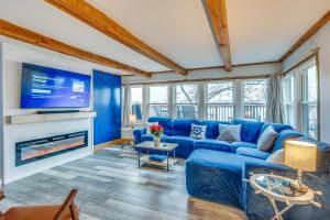 ein blaues Wohnzimmer mit einem blauen Sofa und einem TV in der Unterkunft Waterfront Fox Lake Vacation Rental with Fire Pit! in Fox Lake