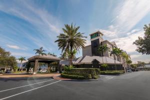 a building with a palm tree in front of a street at La Quinta by Wyndham Miami Airport West in Miami