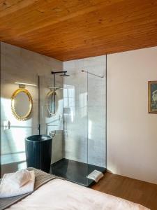 a glass shower in a bedroom with a bed at DU GLACIER Boutique & Traditions Hotel in Fiesch