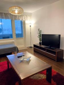 uma sala de estar com uma televisão e uma mesa de centro em Ylimmän kerroksen kaksio Varkaudessa em Varkaus