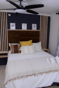 um quarto com uma grande cama branca com almofadas em Kanana Villas em Otse