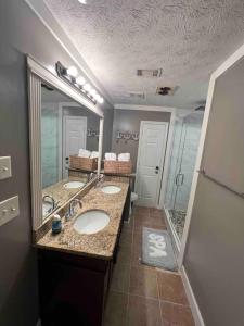 a bathroom with two sinks and a large mirror at Welcome to The Blue House! in Stone Mountain