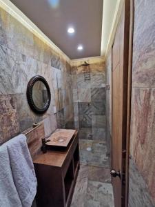 a bathroom with a sink and a shower with a mirror at Hotel Casa Posos in Guanajuato