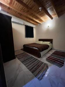 a bedroom with a bed and two rugs on the floor at Apartment dahab in Dahab