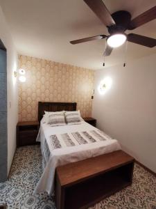 Hotel Casa Posos في غواناخواتو: غرفة نوم بسرير ومروحة سقف