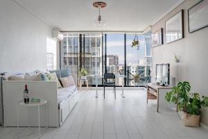 uma sala de estar com um sofá e uma mesa em Ocean view apartment close to CBD with indoor pool. em Melbourne