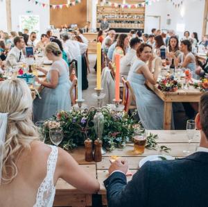 Eine Gruppe von Menschen, die bei einer Hochzeit an Tischen sitzen. in der Unterkunft The Holford Arms in Tetbury