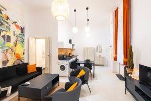 uma sala de estar com um sofá preto e cadeiras em Modern uniquely designed flat Andrassy Avenue and Oktogon square em Budapeste