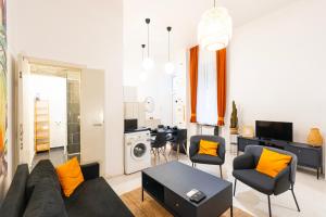 uma sala de estar com um sofá, cadeiras e uma mesa em Modern uniquely designed flat Andrassy Avenue and Oktogon square em Budapeste