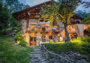 a stone house with a tree in front of it at La Ferme d'Angele in Bourg-Saint-Maurice