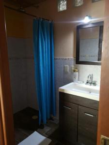 a bathroom with a blue shower curtain and a sink at Xcalak Caribe Lodge in Xcalak