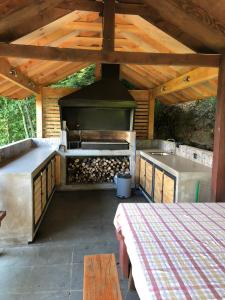 an outdoor kitchen with a grill and a sink at Casa Orilla Lago Villarrica in Villarrica