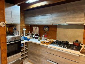 eine Küche mit Holzschränken und einem Herd mit Backofen in der Unterkunft Casa Orilla Lago Villarrica in Villarrica