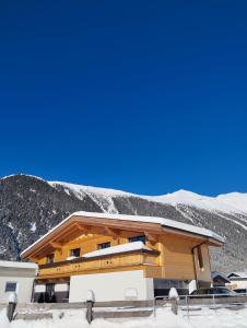 ein Gebäude mit schneebedeckten Bergen im Hintergrund in der Unterkunft Apart Alpenflair in Umhausen