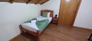 ein Schlafzimmer mit einem Bett und einem Holzboden in der Unterkunft Refúgio do Limoeiro in São Vicente