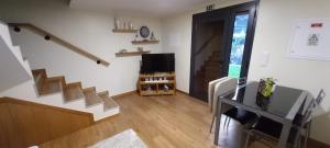 ein Wohnzimmer mit einer Treppe und einem TV in der Unterkunft Refúgio do Limoeiro in São Vicente