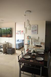 ein Wohnzimmer mit einem Tisch und ein Schlafzimmer in der Unterkunft Condo La Aldea 2 Hab. Vista Única. Muy Tranquilo in Ricaurte
