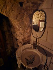 La salle de bains en pierre est pourvue d'un lavabo et d'un miroir. dans l'établissement Parlami d'amore Mariù, à Modugno