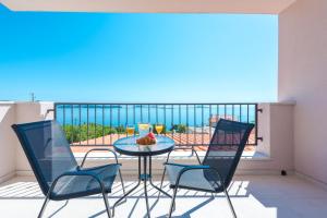 Apartments Villa Made 4U في مْليني: طاولة وكراسي على شرفة مطلة على المحيط