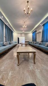 ein großes Wohnzimmer mit einem Tisch und Sofas in der Unterkunft كورال بيت العطلات in Khobar