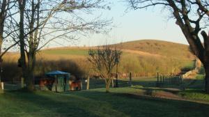 a field with trees and a hill in the background at Lantligt och lugnt boende nära natur och stad in Svedala