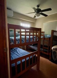 a bedroom with three bunk beds and a ceiling fan at Relaxing family Beach House with Pool in Río Hato