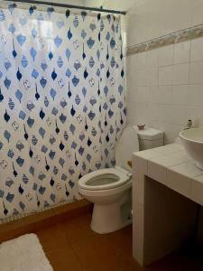 a bathroom with a toilet and a shower curtain at Relaxing family Beach House with Pool in Río Hato