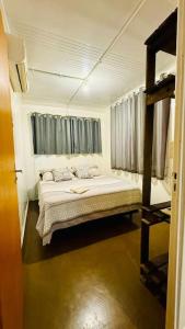Schlafzimmer mit einem Bett und einem Fenster in der Unterkunft Casa Container na Praia do Rosa / Ibiraquera in Imbituba