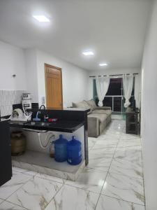 een keuken en een woonkamer met een wastafel en een bank bij Apartamento verão in Vila Velha