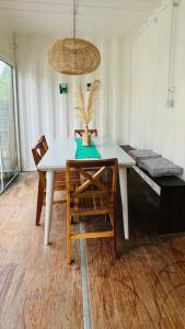 ein Esszimmer mit einem weißen Tisch und Stühlen in der Unterkunft Casa Container na Praia do Rosa / Ibiraquera in Imbituba