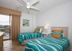 een slaapkamer met 2 bedden en een plafondventilator bij Summer House 306A by ALBVR - Corner Beachfront Condo - Beachfront Balcony Accessible from all Rooms in Orange Beach