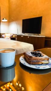 eine Tasse Kaffee und ein Gebäck auf dem Tisch in der Unterkunft Casa H Hotel Boutique in San Luis Potosí