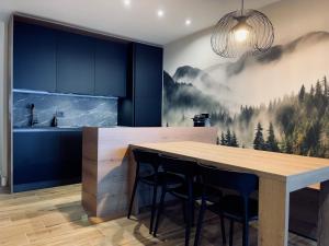 a kitchen with a dining table and a mountain mural at Dolomiti Haus - Immerso nelle Dolomiti in Tesero