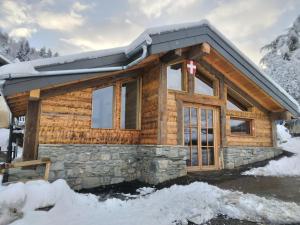 Cabaña de madera con nieve en el techo en Chalet Balnéo Billard La Plagne Savoie Vue TOP, en La Plagne Tarentaise