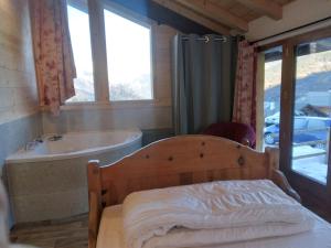 a bedroom with a bed and a bath tub and a sink at Chalet Balnéo Billard La Plagne Savoie Vue TOP in La Plagne Tarentaise