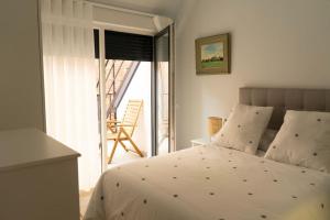 Apartamento NUEVO en el centro de León في ليون: غرفة نوم بسرير وشرفه مع كرسي