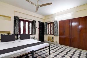 a bedroom with a bed and a ceiling at OYO Simplex Guest House Behala in Kolkata