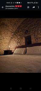 1 dormitorio con 1 cama grande en una pared de piedra en Parlami d'amore Mariù, en Modugno