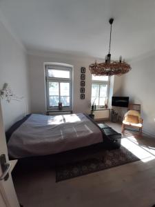 a bedroom with a large bed and a chandelier at City-Apartment 1 in Schwerin