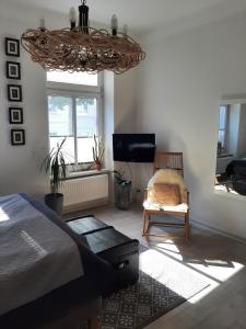 a bedroom with a bed and a chair and a chandelier at City-Apartment 1 in Schwerin