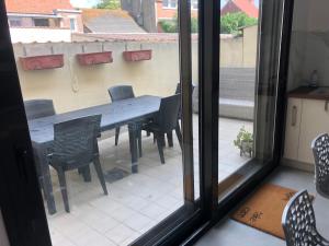 a table and chairs in a room with a window at Family cottage 4 chambres in Bourbourg