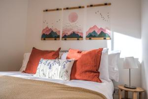 a bedroom with a bed with orange and white pillows at Milia House 2BR in Oxford Centre with free parking in Oxford
