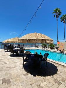 a group of tables and chairs next to a swimming pool at Condo in Waterfront Resort with Balcony Close to Beaches Free Bikes in Dunedin