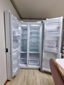 um frigorífico branco com as suas portas abertas numa cozinha em Cooing em Chuncheon