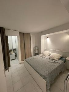 ein Schlafzimmer mit einem großen Bett in einem Zimmer in der Unterkunft Appartement bord de mer avec piscine in Vallauris